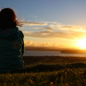 A woman looking into the distant sunset