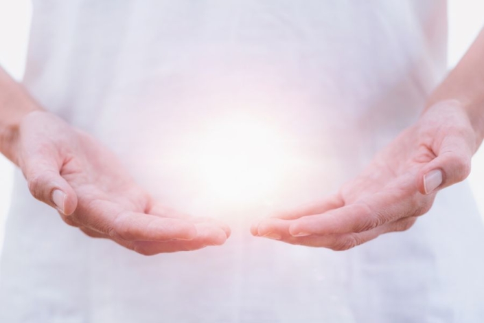 a healing psychic readers hands holding an aura