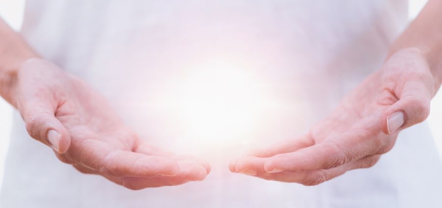 a healing psychic readers hands holding an aura